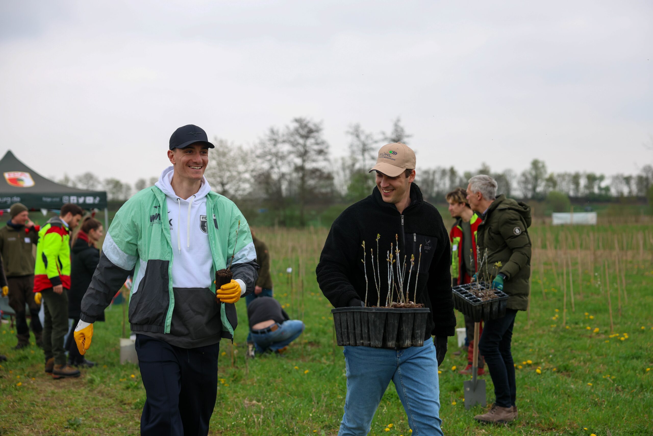 Teilnehmende mit Arbeitshandschuhen bei der Baumpflanzaktion